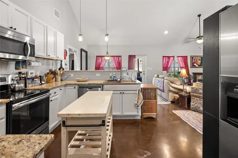 a kitchen with kitchen island a stove and a refrigerator