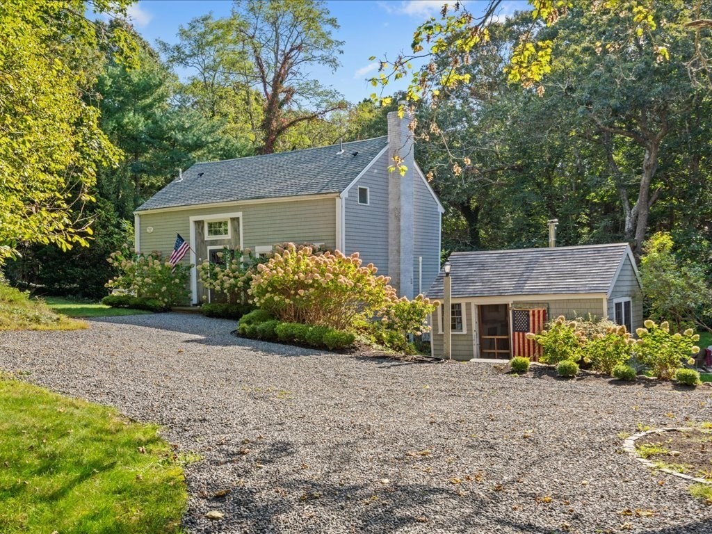 a view of a house with a yard and potted plants
