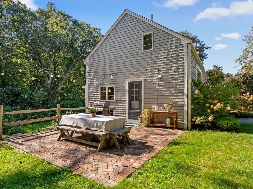 144 Old County Road Sandwich, MA 02537 - Photo 32 of 42 a backyard of a house with a garden and outdoor seating