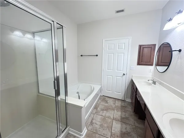 a bathroom with a tub sink and mirror