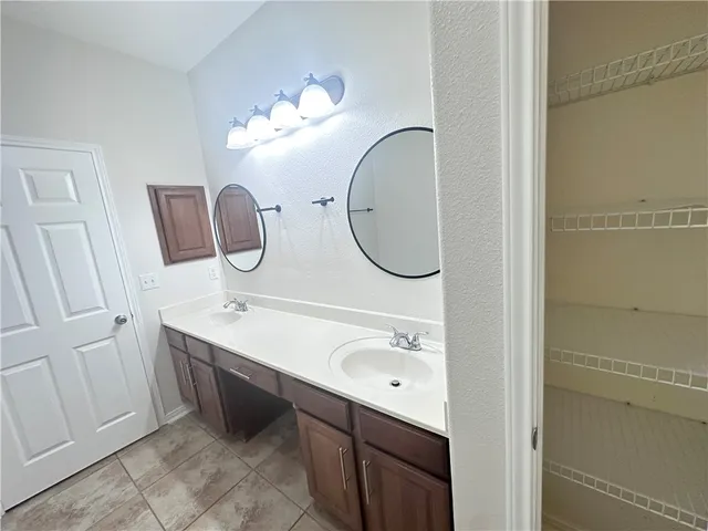 a bathroom with a double vanity sink and a mirror