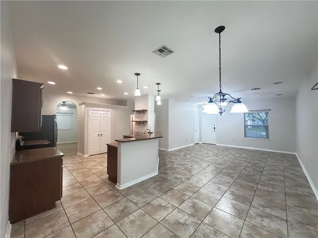a view of a kitchen with kitchen island a counter top space appliances and cabinets