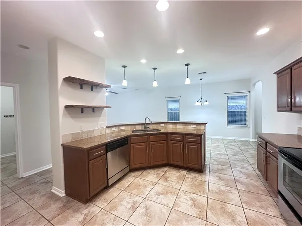 a large kitchen with stainless steel appliances granite countertop a sink and cabinets