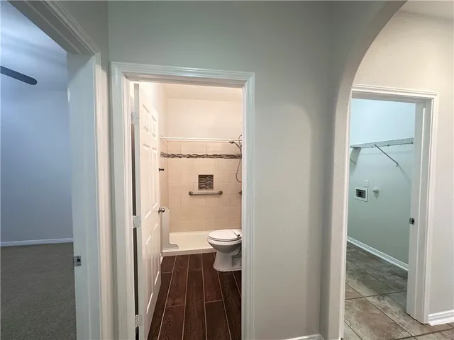 a bathroom with a granite countertop toilet a sink and a shower