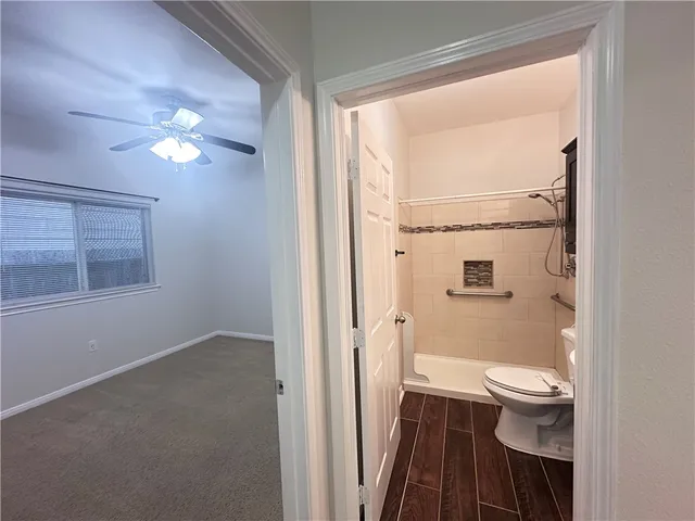 a bathroom with a light fixture a toilet and a shower