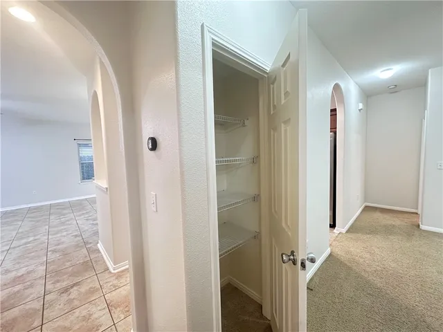a view of a hallway with closet and bathroom