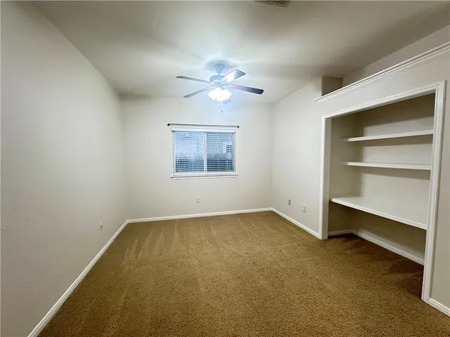 an empty room with a empty space and a ceiling fan