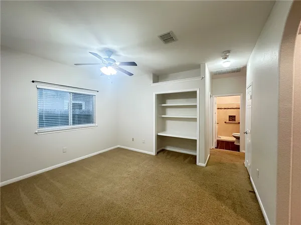 a view of an empty room with a ceiling fan