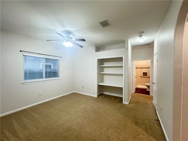 a view of an empty room with a ceiling fan