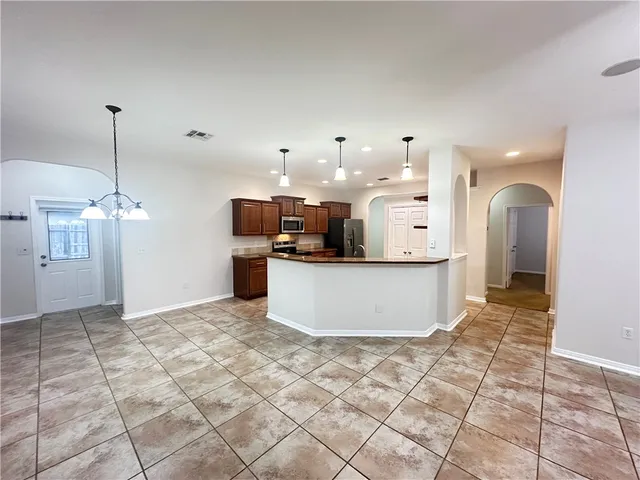 a large kitchen with stainless steel appliances kitchen island granite countertop a large counter top and cabinets