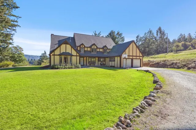 a view of a house with a yard and porch