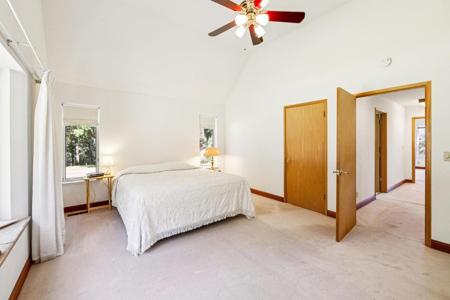 24595 Skyland Road Los Gatos, CA 95033 - Photo 40 of 68 a spacious bedroom with a bed and a chandelier