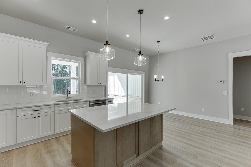 125 Rains Road Jefferson, GA 30549 - Photo 14 of 43 a kitchen with granite countertop a sink cabinets and wooden floor