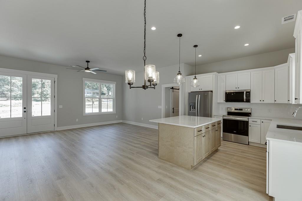125 Rains Road Jefferson, GA 30549 - Photo 16 of 43 a view of kitchen with stainless steel appliances granite countertop cabinets and wooden floor