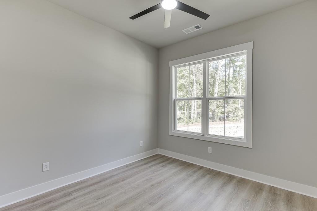 125 Rains Road Jefferson, GA 30549 - Photo 18 of 43 an empty room with wooden floor and windows