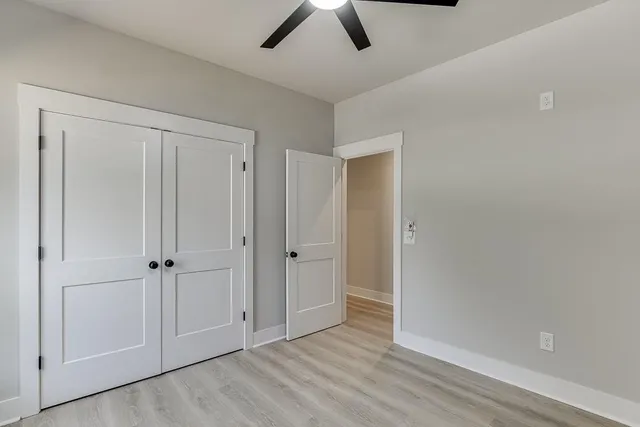 an empty room with a window and a fan