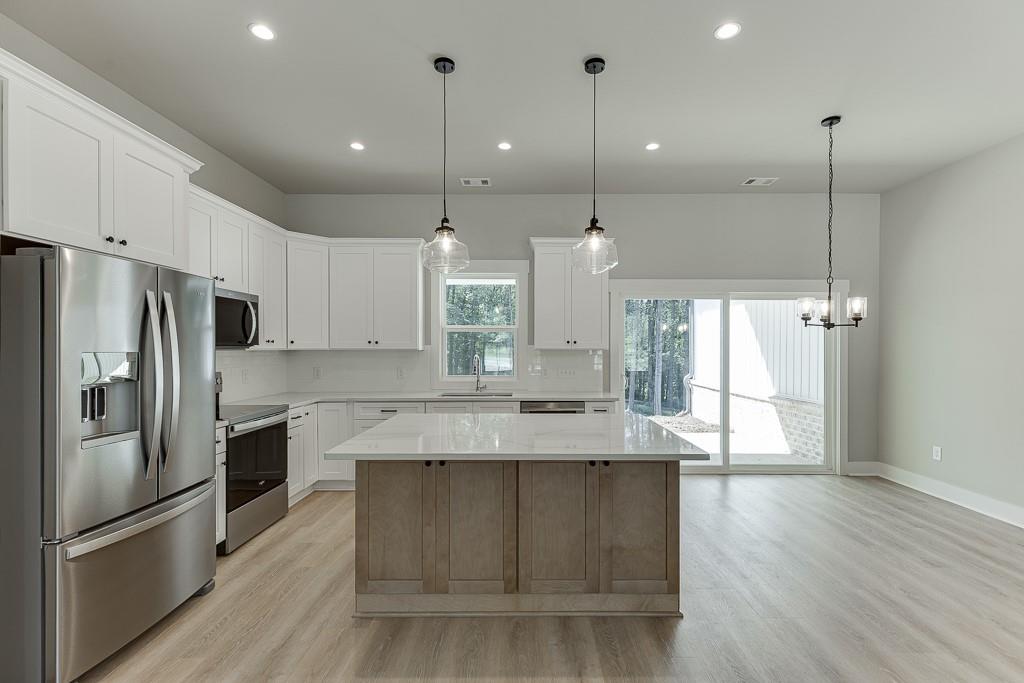 125 Rains Road Jefferson, GA 30549 - Photo 9 of 43 a large kitchen with stainless steel appliances kitchen island granite countertop a refrigerator a oven and a wooden floors