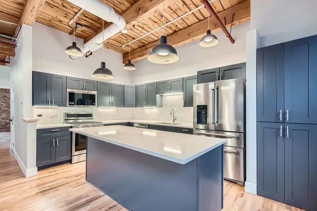 a kitchen with stainless steel appliances a sink and a refrigerator