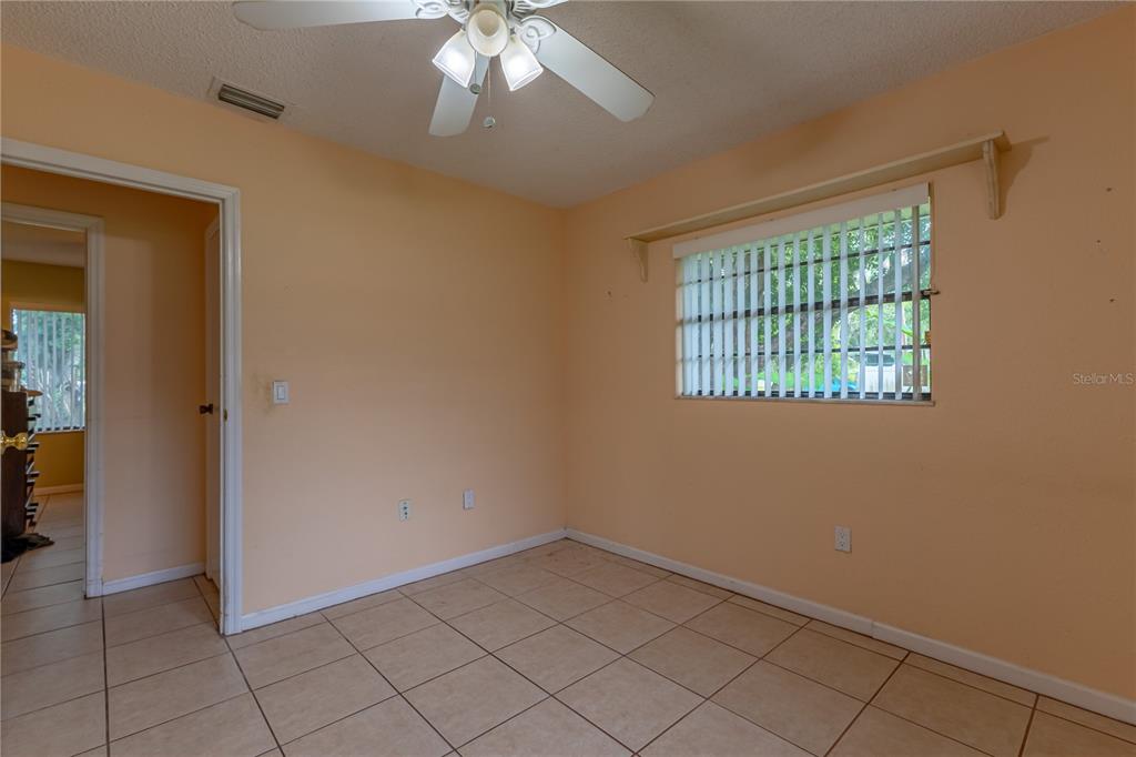 9349 Edison Road Lithia, FL 33547 - Photo 22 of 27 an empty room with windows and chandelier fan