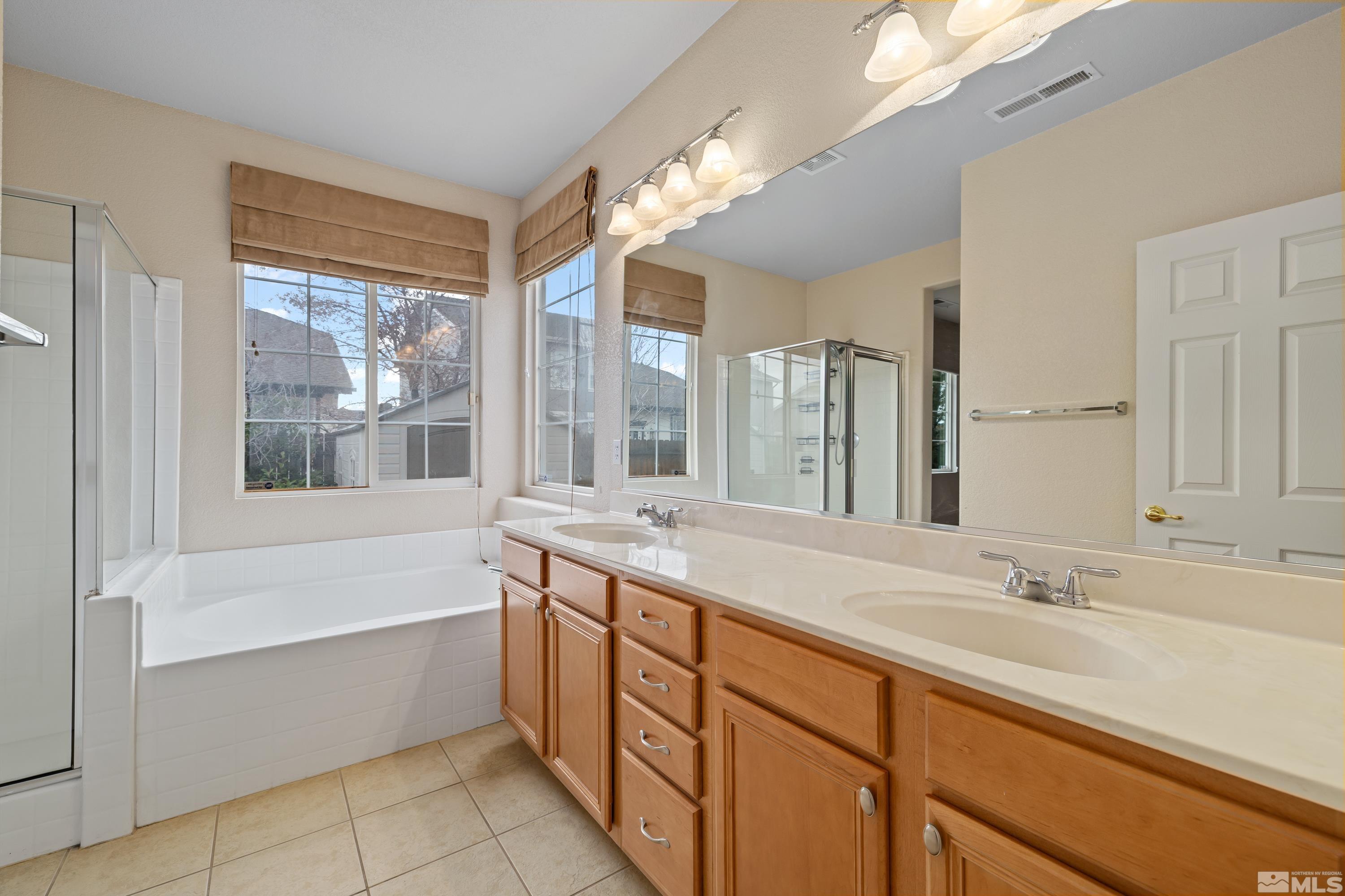 8900 Sorcha Street Reno, NV 89506 - Photo 17 of 39 a bathroom with a tub sink and mirror