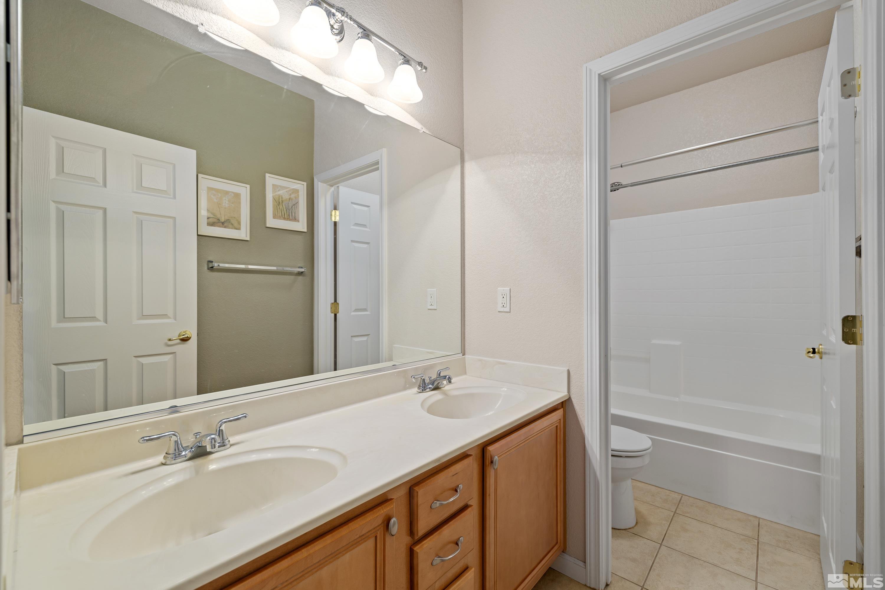8900 Sorcha Street Reno, NV 89506 - Photo 27 of 39 a bathroom with a granite countertop sink and a mirror