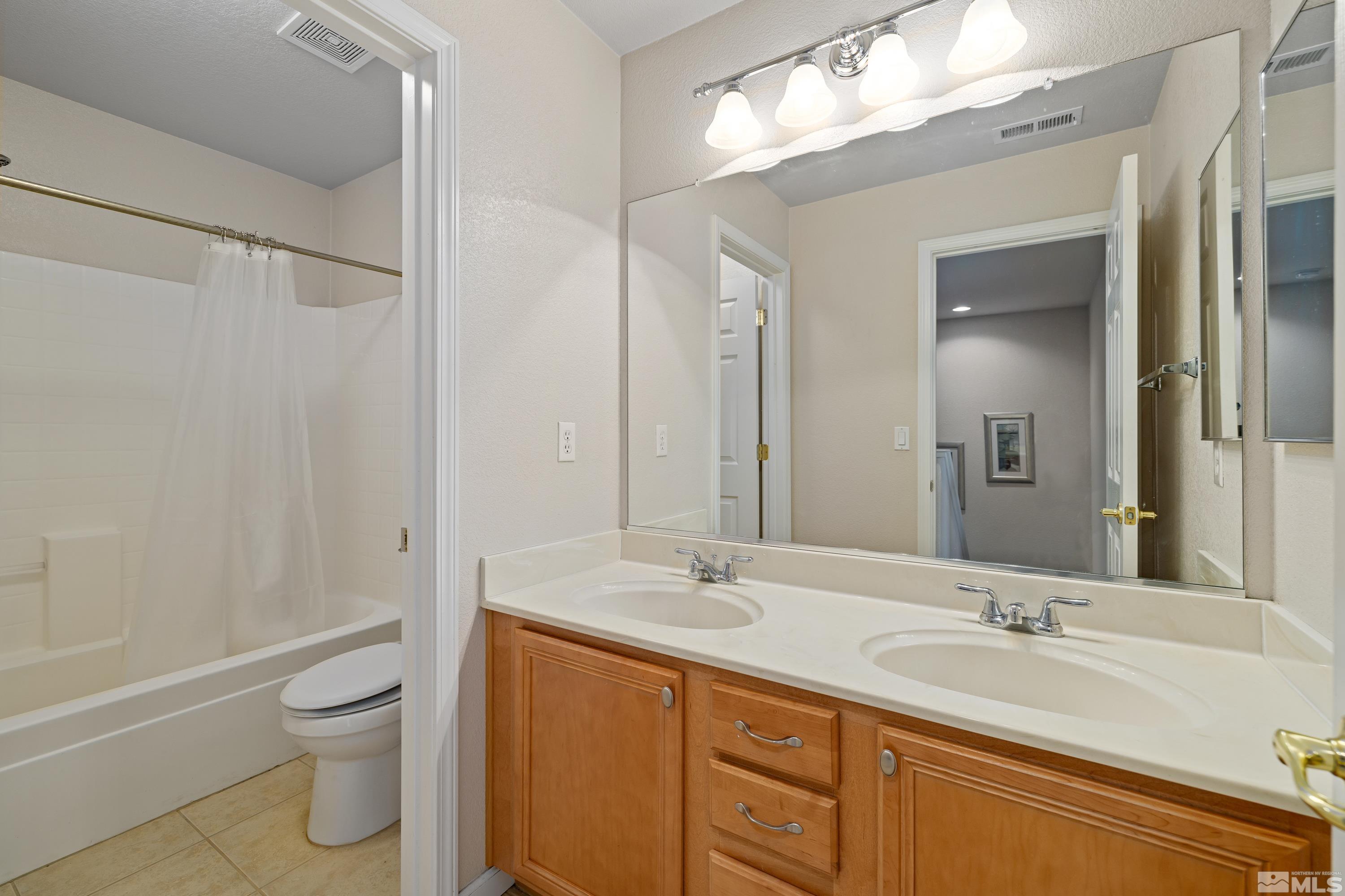 8900 Sorcha Street Reno, NV 89506 - Photo 32 of 39 a bathroom with a granite countertop sink a toilet and a bathtub