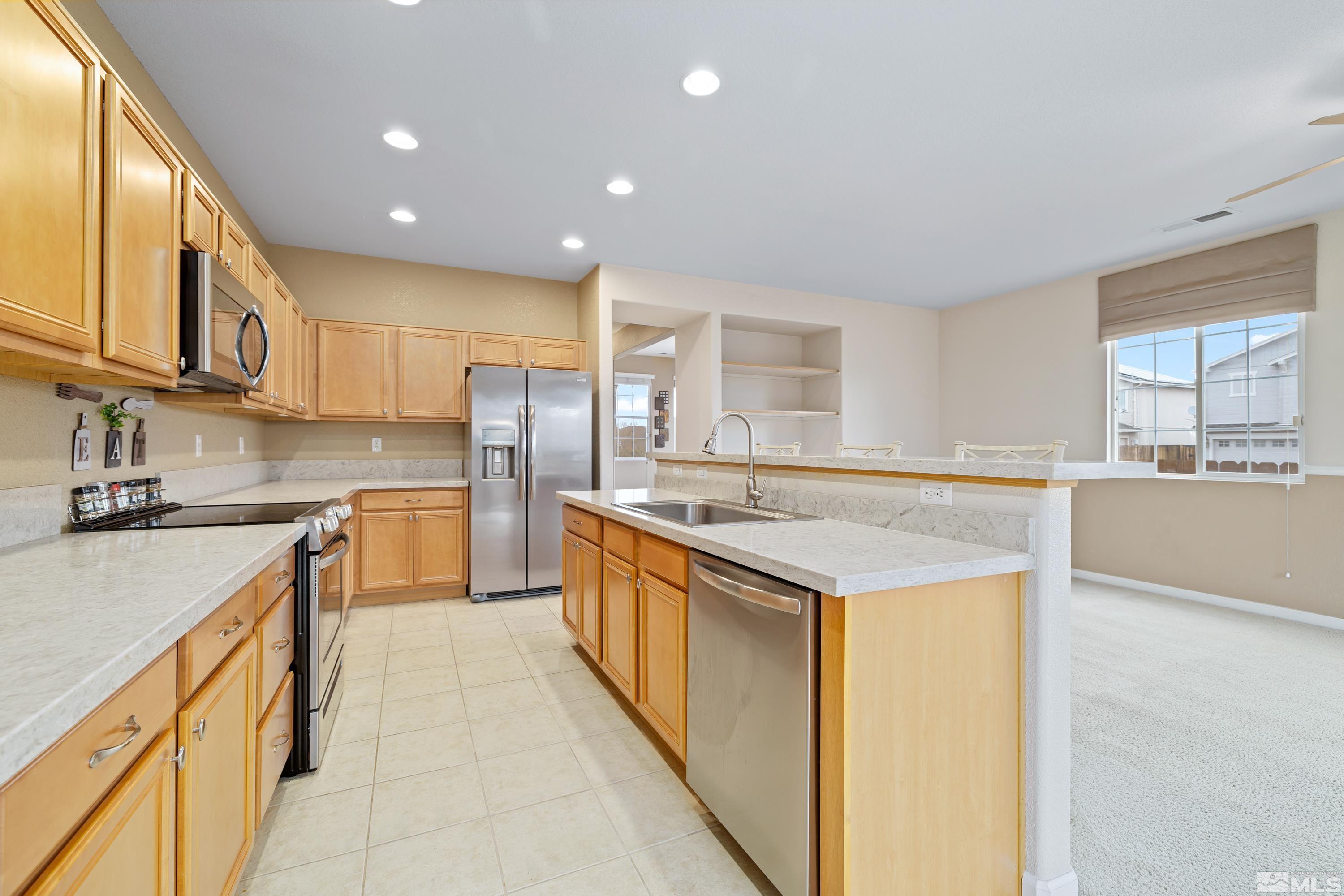 8900 Sorcha Street Reno, NV 89506 - Photo 9 of 39 a large kitchen with stainless steel appliances granite countertop a large kitchen counter top a stove and a sink