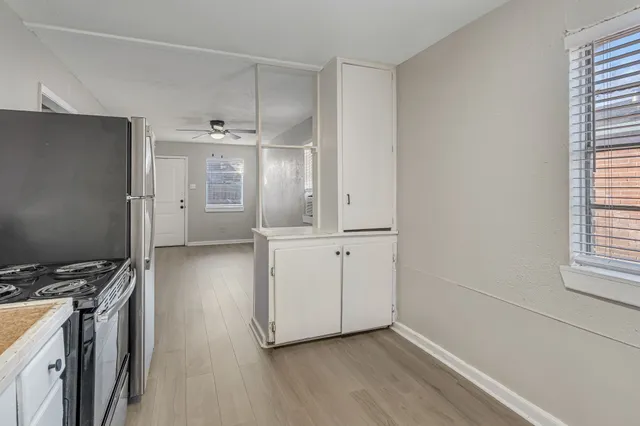 a view of a kitchen with wooden floor and electronic appliances