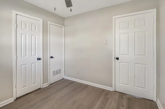 a view of an empty room with wooden floor