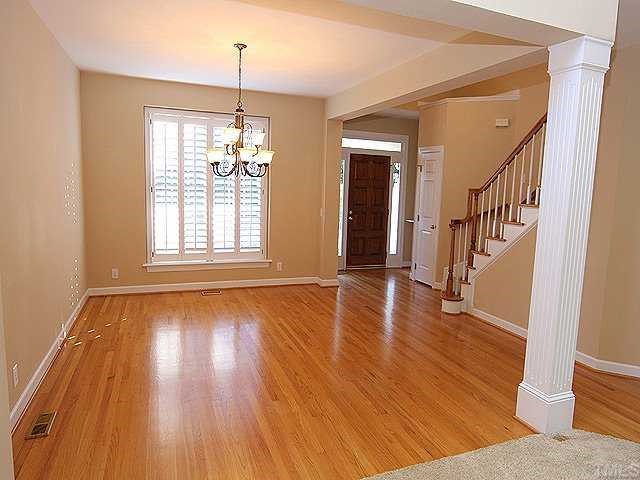 2936 Tillinghast Trail Raleigh, NC 27613 - Photo 2 of 12 a view of an empty room with wooden floor and a window