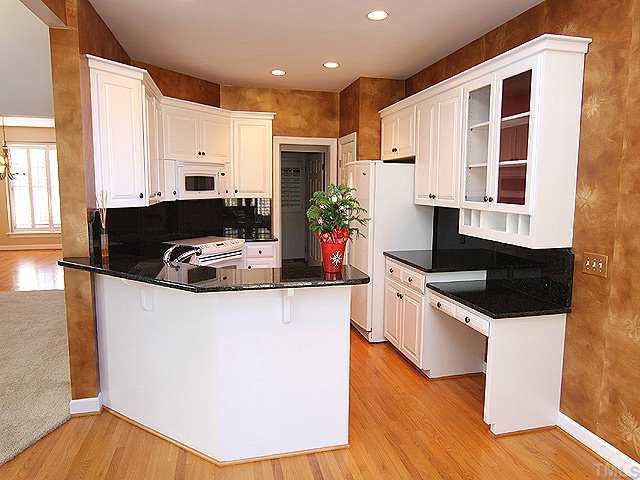2936 Tillinghast Trail Raleigh, NC 27613 - Photo 3 of 12 a kitchen with stainless steel appliances granite countertop a sink a stove and a refrigerator