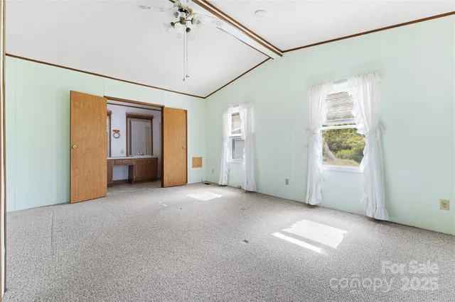 a view of a big room with windows and chandelier