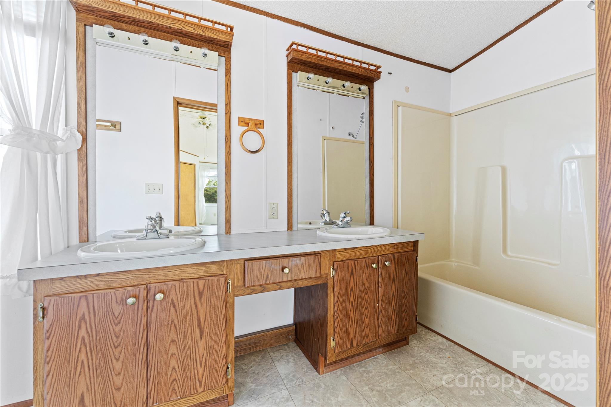 112 Melody Street Clyde, NC 28721 - Photo 33 of 47 a bathroom with a granite countertop sink a mirror and a bathtub next to a window