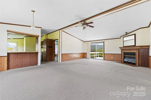 a view of an empty room with a fireplace and a window