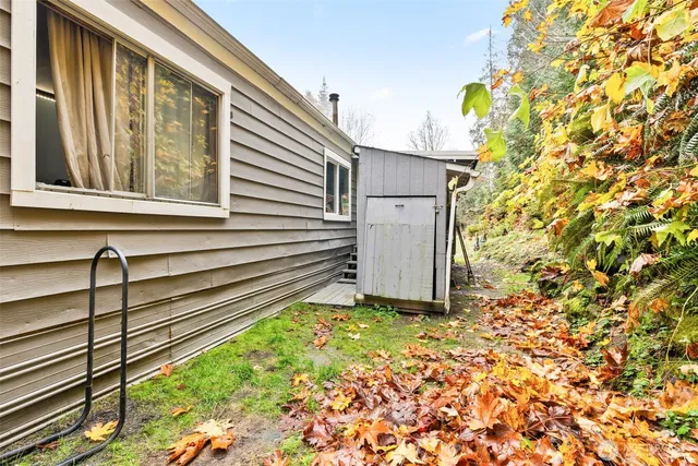 a view of backyard with wooden fence and trees