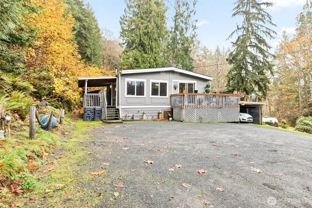 an aerial view of a house with a yard and trees all around