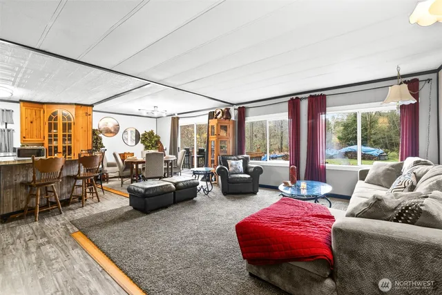 a living room with furniture floor to ceiling window and a flat screen tv