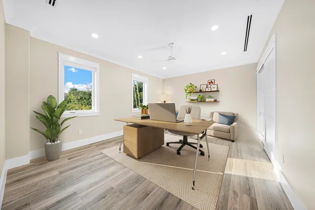 a living room with furniture a potted plant and open kitchen view