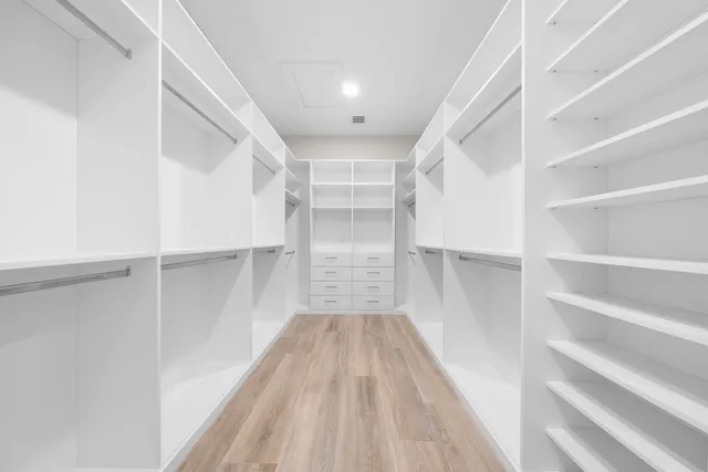 a view of walk in closet with empty racks