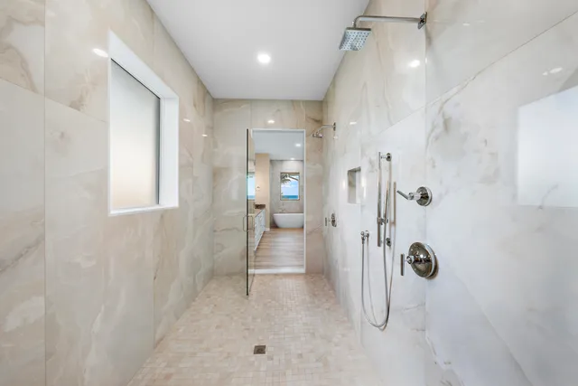 a room with a bed and a potted plant on the dresser