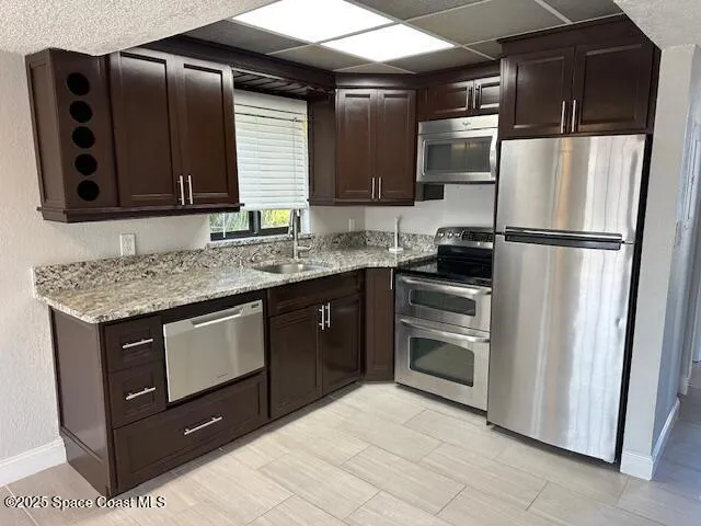 a kitchen with stainless steel appliances granite countertop a refrigerator and a sink
