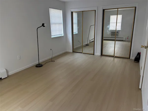 a view of a room with wooden floor and a bathroom