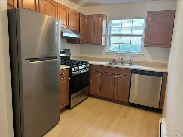 a kitchen with stainless steel appliances granite countertop a refrigerator stove and sink