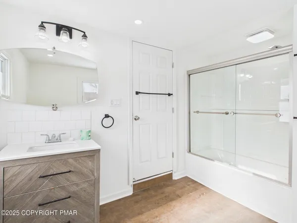 a bathroom with a shower sink and mirror