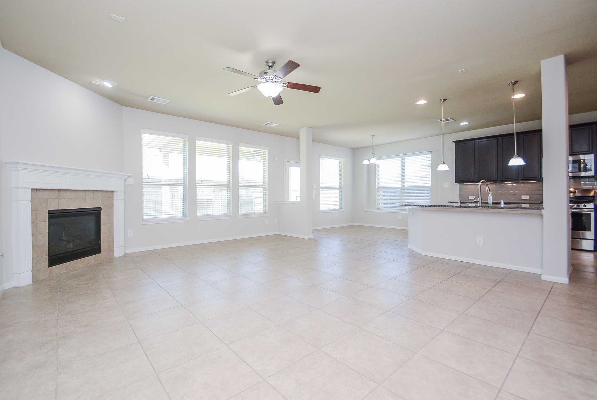 7418 Wilson Reach Lane Spring, TX 77389 - Photo 8 of 32 Well-lit living room featuring a fireplace and ceiling fan.