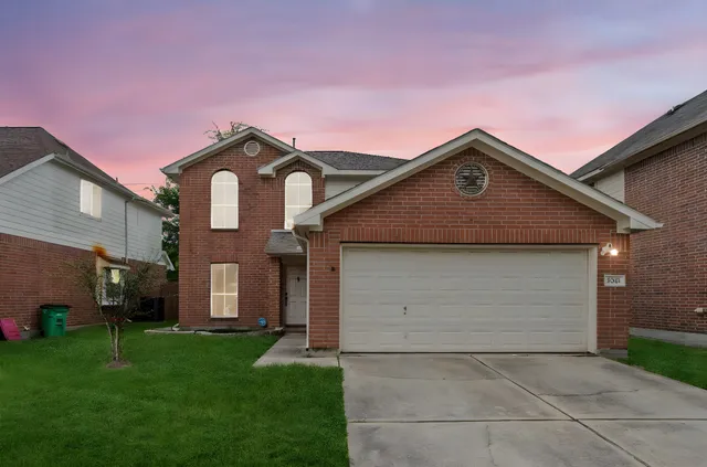 a front view of a house with a garden and garage