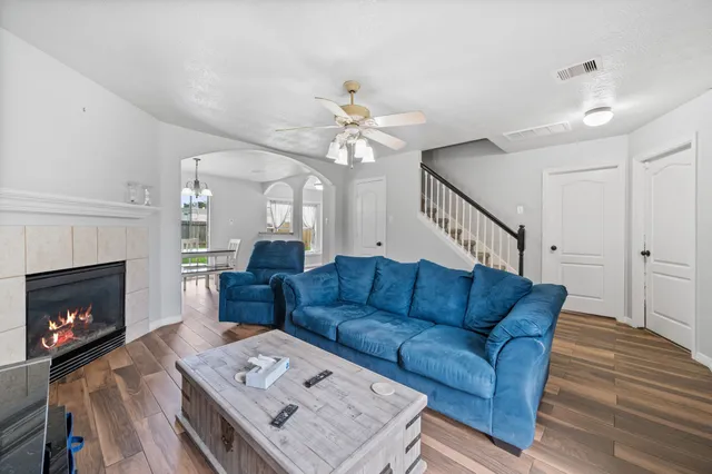 a living room with furniture a fireplace and a chandelier