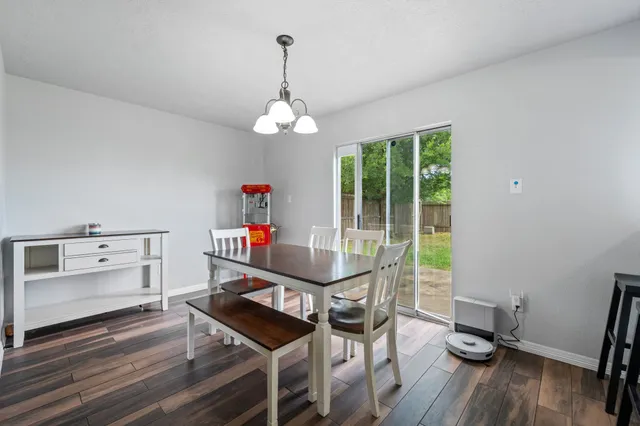 a view of a dining room with furniture a chandelier and wooden floor