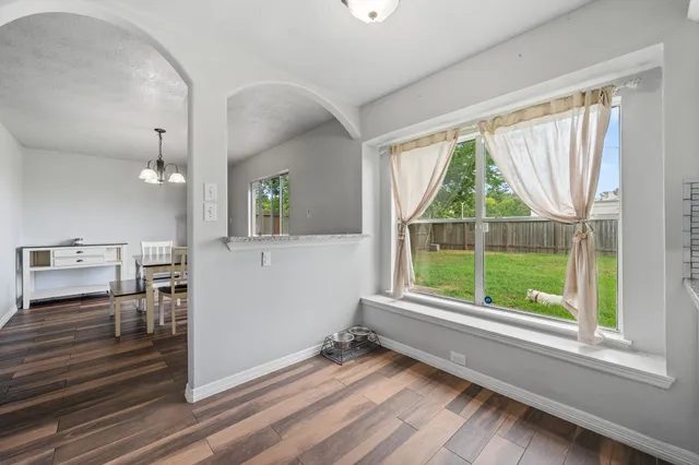 a view of a room with wooden floor and windows