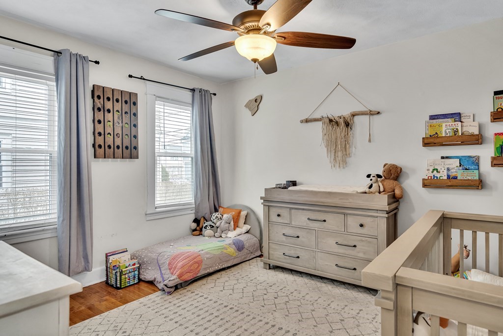 63-65 Brookley Road, Unit 1 Boston, MA 02130 - Photo 13 of 20 a bedroom with a bed and a chandelier